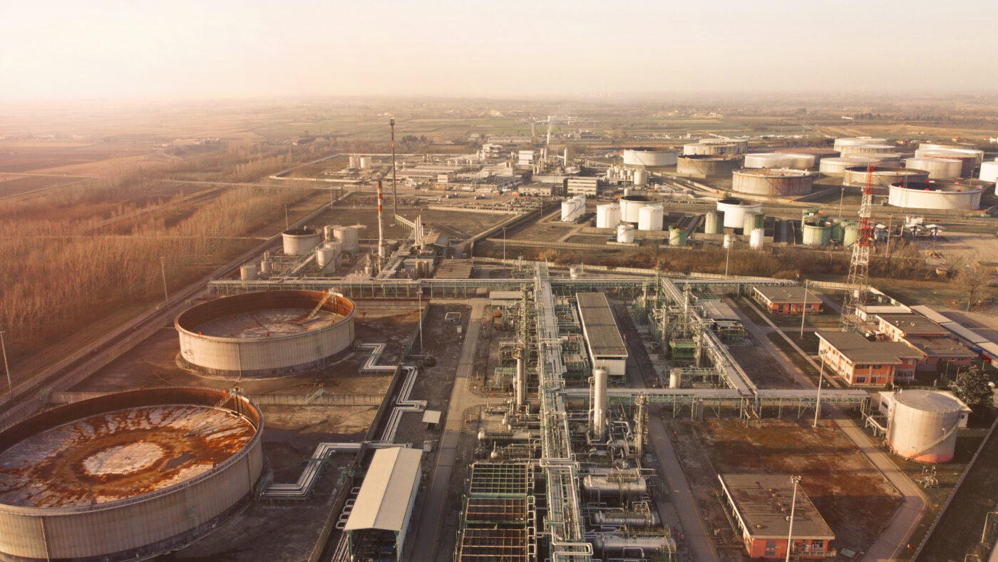 Drone view of a large industrial oil refinery with storage tanks and processing equipment